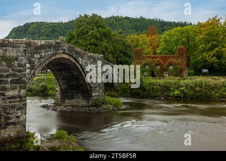 Lo storico ponte Pont Fawr e il tu Hwnt i'r Bont Tearooms a Llanrwst, Galles. Foto Stock