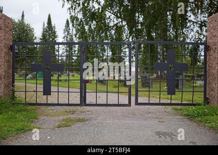 Ingresso al cimitero con vecchia porta in ferro battuto con croci. Foto Stock