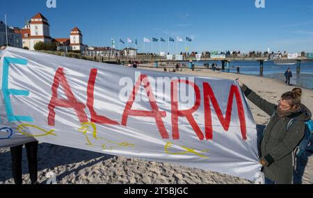 4 novembre 2023, Meclemburgo-Pomerania occidentale, Binz: Partecipanti alla manifestazione organizzata dall'alleanza "Flagge zeigen - LNG-protesta sichtbar machen!" hanno stampigliato striscioni sul molo della località balneare. Non lontano dal sito del previsto terminal GNL nel porto di Mukran sul molo di Binz, circa 100 persone stanno manifestando contro il progetto, secondo i rapporti della polizia. Di recente, si sono moltiplicate le speculazioni su possibili ragioni per un avvio significativamente più tardi del terminale GNL di Rügen e presunte indicazioni in merito. Autorità e un progetto di sviluppo Foto Stock