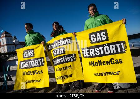 4 novembre 2023, Meclemburgo-Pomerania Occidentale, Binz: Gli attivisti di Greenpeace sono in piedi con uno striscione sul molo. La dimostrazione dell'alleanza "Flagge zeigen - LNG-protesta sichtbar machen!” Ha richiesto una fermata al terminale GNL di Rügen. Non lontano dal sito del previsto terminal GNL nel porto di Mukran sul molo di Binz, circa 100 persone hanno manifestato contro il progetto, secondo i rapporti della polizia. Di recente, si sono moltiplicate le speculazioni su possibili ragioni per un avvio significativamente più tardi del terminale GNL di Rügen e presunte indicazioni in merito. Autorità e un progetto Foto Stock