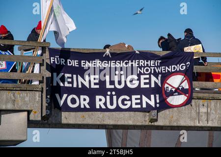 4 novembre 2023, Meclemburgo-Pomerania occidentale, Binz: Partecipanti alla manifestazione organizzata dall'alleanza "Flagge zeigen - LNG-protesta sichtbar machen!" hanno stampigliato striscioni sul molo della località balneare. Non lontano dal sito del previsto terminal GNL nel porto di Mukran sul molo di Binz, circa 100 persone stanno manifestando contro il progetto, secondo i rapporti della polizia. Di recente, si sono moltiplicate le speculazioni su possibili ragioni per un avvio significativamente più tardi del terminale GNL di Rügen e presunte indicazioni in merito. Autorità e un progetto di sviluppo Foto Stock