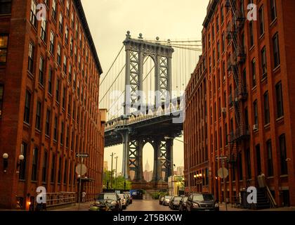 Una splendida foto del famoso Manhattan Bridge, incorniciato dal vivace quartiere DUMBO di Brooklyn. La foto cattura il neo-Gothi del ponte Foto Stock