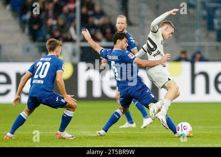 Sinsheim, Germania. 4 novembre 2023. Calcio: Bundesliga, TSG 1899 Hoffenheim - Bayer Leverkusen, Matchday 10, PreZero Arena. Finn Ole Becker di Hoffenheim (l-r), Ozan Kabak di Hoffenheim e Florian Wirtz di Leverkusen combattono per il pallone. Credito: Uwe Anspach/dpa - NOTA IMPORTANTE: in conformità con le norme della DFL German Football League e della DFB German Football Association, è vietato utilizzare o utilizzare fotografie scattate nello stadio e/o della partita sotto forma di immagini sequenziali e/o serie di foto simili a video./dpa/Alamy Live News Foto Stock