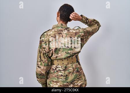 Bella donna afro-americana che indossa l'uniforme mimetica dell'esercito all'indietro pensando al dubbio con la mano sulla testa Foto Stock