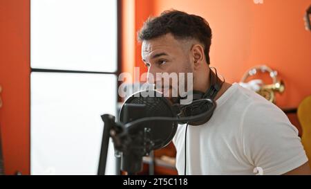 Giovane musicista arabo che canta canzoni nello studio di musica Foto Stock