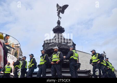 Londra, Regno Unito. 4 novembre 2023. Gli agenti di polizia sorvegliano la Shaftesbury Memorial Fountain, alias Eros, a Piccadilly Circus. Un gruppo di manifestanti ha marciato nel centro di Londra e si è Unito a decine di migliaia di persone per una manifestazione a Trafalgar Square chiedendo un cessate il fuoco e in solidarietà con la Palestina mentre la guerra Israele-Hamas si intensifica. Credito: Vuk Valcic/Alamy Live News Foto Stock