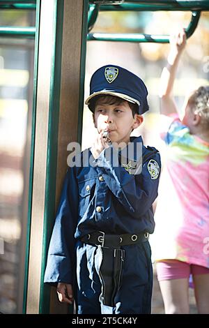 Halloweenpalooza - Dennis, Massachusetts a Cape Cod. Una festa di famiglia di Halloween. Un giovane ragazzo vestito con l'uniforme di un poliziotto Foto Stock