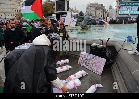 Londra, Regno Unito. 4 novembre 2023. Migliaia di persone si sono riunite in Piazza Trafalgar a sostegno del popolo palestinese nella striscia di Gaza chiedendo la fine dei bombardamenti contro i civili. Le donne mettono le effigie di bambini sotto le foto di bambini uccisi nel conflitto. Crediti: Uwe Deffner/Alamy Live News Foto Stock