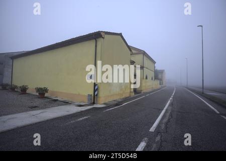 Manor ai margini di una strada in una giornata nebbiosa nella campagna italiana Foto Stock