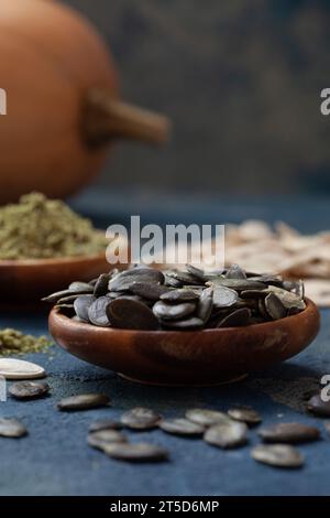 Semi di zucca sbucciati e macinati in ciotole di legno. Cibo sano, biologico pieno di vitamine e antiossidanti, rimedio per problemi alla prostata. Foto Stock