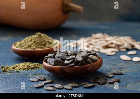 Semi di zucca sbucciati e macinati in ciotole di legno. Cibo sano, biologico pieno di vitamine e antiossidanti, rimedio per problemi alla prostata. Foto Stock