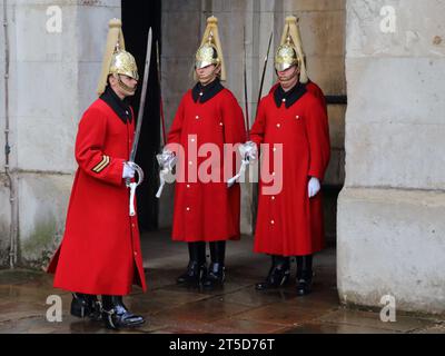 I soldati della guardia del Re al cambio della guardia con le loro uniformi cerimoniali indossando lunghi cappotti per il freddo periodo dell'anno a Whitehall, Londra, Regno Unito Foto Stock