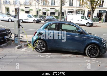 Auto elettrica in carica presso la stazione di ricarica nel centro di Parigi, Francia Foto Stock