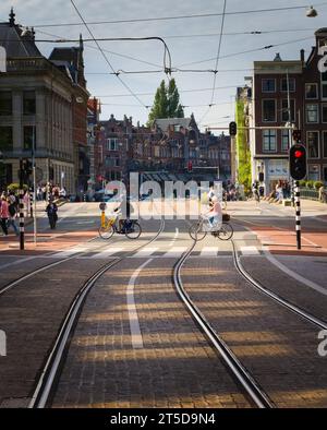 Coppia anziana in bicicletta dall'altra parte della strada ad Amsterdam, Paesi Bassi. Foto Stock