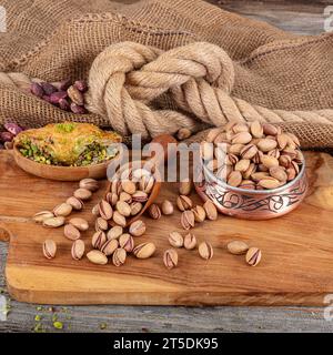 Pistacchi brevemente in ciotola di rame su fondo rustico in legno, meravigliosa composizione di pistacchio per una nutrizione sana e dietetica. Concetto di pistacchio. Foto Stock