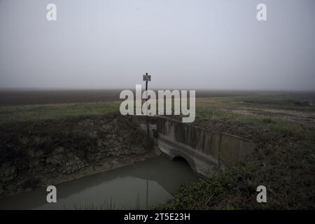 Ingresso a un campo con un cartello sopra una foschia in una giornata nella campagna italiana Foto Stock