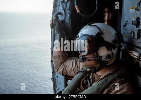 231027-N-LK647-1425 MAR MEDITERRANEO (27 ottobre 2023) Naval Aircrewman (Tactical Helicopter) 2nd Class Devin Morgan, assegnato allo “Spartans” of Helicopter Maritime Strike Squadron (HSM) 70, da New Orleans, Louisiana, si prepara ad atterrare durante le operazioni di volo di routine, 27 ottobre 2023. La Normandia fa parte del Gerald R. Ford Carrier Strike Group e attualmente opera nel Mar Mediterraneo, sotto la direzione del Segretario della difesa. Gli Stati Uniti mantengono forze schierate in avanti, pronte e posturate per scoraggiare l'aggressione e sostenere la sicurezza e la stabilità in tutto il mondo. (Foto U.S. Navy Foto Stock