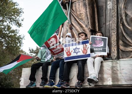 Istanbul, Turchia. 4 novembre 2023. Durante la protesta, i bambini salirono sulla statua monumentale e sostennero la Palestina con la bandiera palestinese e gli striscioni che tenevano nelle loro mani durante la manifestazione pro-Palestina. Mentre continuano gli attacchi israeliani ai civili a Gaza, i sostenitori palestinesi protestano a Istanbul contro la visita del Segretario di Stato americano Antony Blinken in Turchia, gridando slogan con striscioni che tenevano in mano. Dopo il comunicato stampa, i manifestanti pregarono e terminarono la protesta. Credito: SOPA Images Limited/Alamy Live News Foto Stock