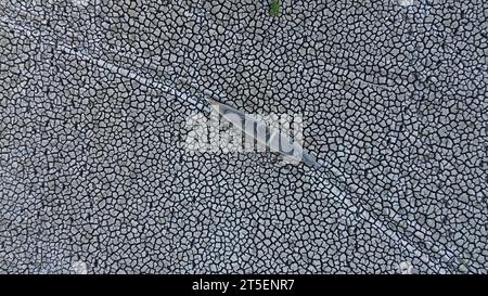 Vista aerea di una vecchia barca sul lago asciutto di Limboto. Vista aerea di una barca di legno rotta abbandonata sulla terraferma. Riscaldamento globale Foto Stock