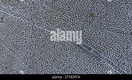 Vista aerea di una vecchia barca sul lago asciutto di Limboto. Vista aerea di una barca di legno rotta abbandonata sulla terraferma. Riscaldamento globale Foto Stock