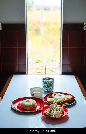 Un menu' di piatti tipici malesi o piatti. Nasi Hainan, Nasi Lemak, e una tazza di caffè. Verticale o verticale. Foto Stock