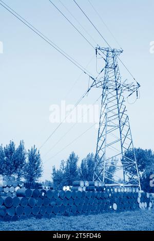 fusti di olio e torre elettrica in un'area di stoccaggio Foto Stock