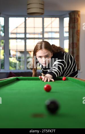 Adolescente che gioca a bagatelle in una tradizionale partita da pub nella sala a casa Foto Stock