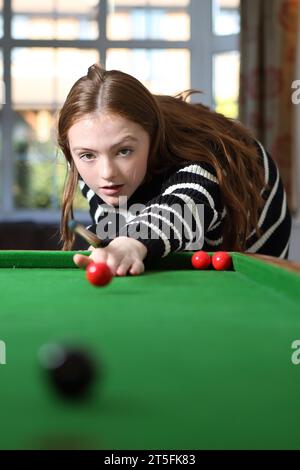 Adolescente che gioca a bagatelle in una tradizionale partita da pub nella sala a casa Foto Stock