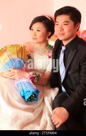 CONTEA DI LUANNAN - DICEMBRE 29: Una giovane coppia seduta insieme, in attesa di una vita migliore in futuro, nel matrimonio cinese, il 29 dicembre 2013, Foto Stock
