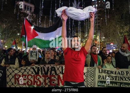 Barcellona, Spagna. 4 novembre 2023. Un uomo solleva un manichino avvolto in fogli che finge di essere un bambino morto, durante la marcia pro-palestinese. Quasi 1.000 persone hanno manifestato nel cuore di Barcellona per mostrare il loro sostegno al popolo palestinese. (Foto di Ximena Borrazas/SOPA Images/Sipa USA) credito: SIPA USA/Alamy Live News Foto Stock