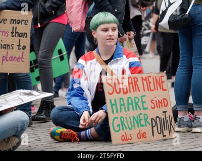 Una giovane donna che manifesta contro il cambiamento climatico. Foto Stock