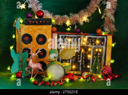 Strumenti musicali per natale con modelli di cartone grungo di strumenti musicali, sintetizzatore, drum kit, chitarra, amplificatore, microfono e natale Foto Stock