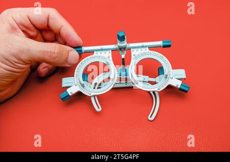 Dispositivo oftalmologico per la selezione degli occhiali. Correzione del miglioramento della visione. Sfondo rosso Foto Stock