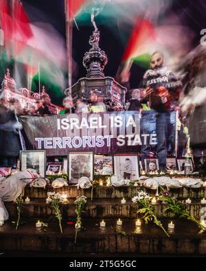 "Israele è uno Stato terrorista”, segno di una veglia a favore della Palestina sotto anteros a Piccadilly Circus a Londra. Foto Stock