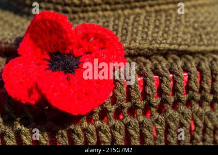 Poole, Dorset, Regno Unito. 5 novembre 2023. Un toccante cupolino a maglia con stivali e cappello da soldato e papaveri rossi a Poole, Dorset, mentre si avvicina il Remembrance Day e ricordiamo coloro che hanno combattuto coraggiosamente nelle guerre. - suola per posta, ciotola per cassetta per lettere, ciotola per cassetta per lettere, ciotoli, bombe su filati, bomba a filato. Crediti: Carolyn Jenkins/Alamy Live News Foto Stock