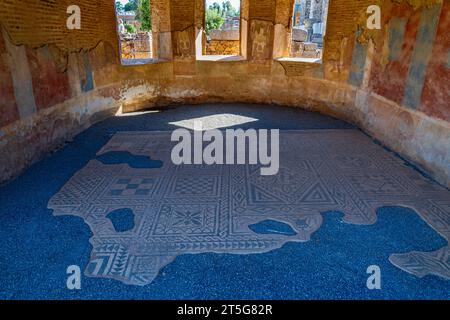 Mosaici restaurati e pareti dipinte di arte romana della Casa del Teatro o della Basilica con luce solare che scorre attraverso le sue finestre. Merid Foto Stock