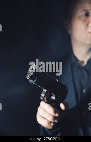 Il sicario mercenario spy assasin detective con un ritratto a pistola scattato in studio. Foto Stock