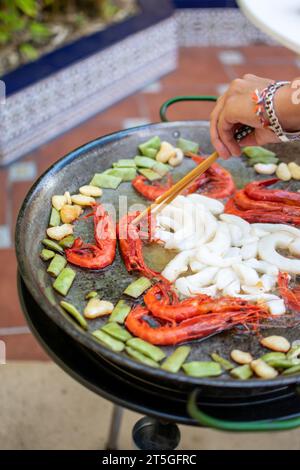 Immagine del processo di cottura della paella in un ambiente familiare. Ricetta spagnola Foto Stock