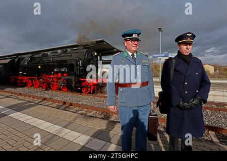 Blankenburg, Germania. 5 novembre 2023. Due appassionati della ferrovia indossano uniformi storiche durante un viaggio speciale con una vecchia locomotiva a vapore alla stazione di Halberstadt. Il viaggio speciale con locomotiva a vapore 95 027 è stato organizzato per celebrare il 100 ° compleanno della locomotiva a vapore. Il gruppo di lavoro di Rübelandbahn fece circolare la storica locomotiva a vapore da Blankenburg a Halberstadt in due giorni. Crediti: Matthias Bein/dpa/ZB/dpa/Alamy Live News Foto Stock