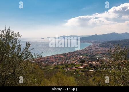 Vista sopraelevata della Riviera delle Palme da un oliveto con le città costiere di pietra Ligure e Loano, e l'Isola della Gallinara, Savona, Liguria Foto Stock