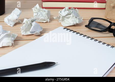 Blocco note con sfondo di carta spazzatura su scrivania in legno. Copia spazio. Foto Stock