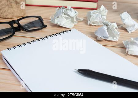 Blocco note con sfondo di carta spazzatura su scrivania in legno. Copia spazio. Foto Stock