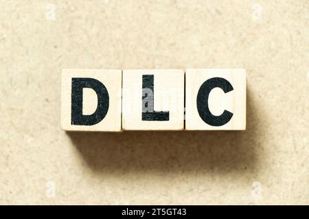 Blocco alfabetico in parola DLC (abbreviazione del contenuto scaricabile) su sfondo legno Foto Stock