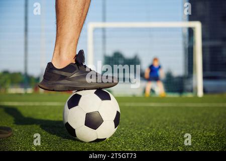 Famiglia felice che gioca a calcio sul campo, concentrati sul piede del padre sulla palla Foto Stock