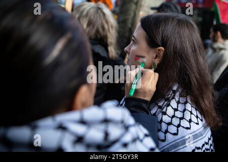 Londra, Regno Unito. 4 novembre 2023. Un manifestante visto essere dipinto con i colori di una bandiera palestinese sulla guancia mentre si riuniscono fuori da una filiale della banca Barclays durante la manifestazione. Migliaia di manifestanti si sono riuniti in solidarietà con il popolo palestinese mentre il conflitto tra Israele e Gaza continua ad intensificarsi a seguito dell'attacco senza precedenti di Hamas all'inizio di ottobre. (Immagine di credito: © Christopher Walls/SOPA Images via ZUMA Press Wire) SOLO USO EDITORIALE! Non per USO commerciale! Foto Stock