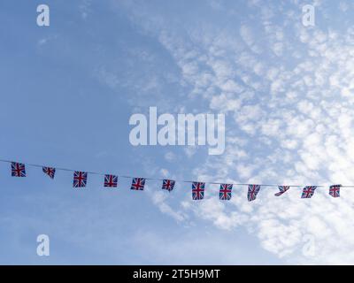 Una linea di bandiere Union Jack, che si estende su un cielo estivo. Foto Stock