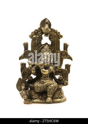 idolo decorativo in bronzo del dio indù krishna con un flauto seduto su un trono di pavone isolato su uno sfondo bianco Foto Stock