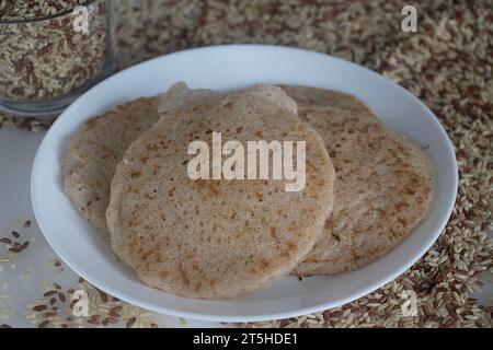 Deliziosi pancake di riso Rajamudi preparati con impasto di riso rajamudi fermentato e latte di cocco. Una prelibatezza dell'India del Sud, splendidamente organizzata su una p Foto Stock