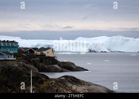 Costa rocciosa con iceberg della piccola comunità di Ilulissat, Groenlandia, Danimarca Foto Stock
