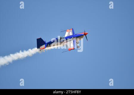 Skopje, Macedonia. L'aereo acrobatico francese Extra 330SC con una scia di fumo ha compiuto miracoli sulle teste degli spettatori. Foto Stock